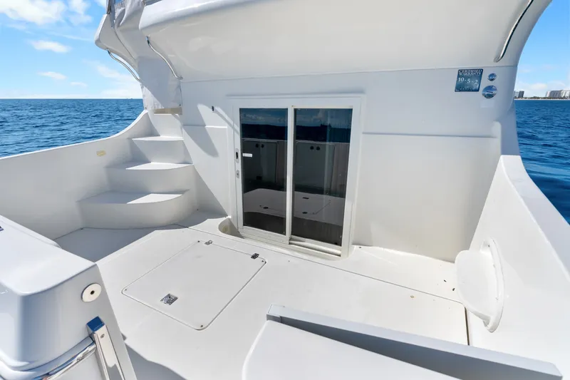 Slide: The Image of 2012 Carver 41 Cockpit Motor Yacht deck with ocean view and sliding glass door. - 17