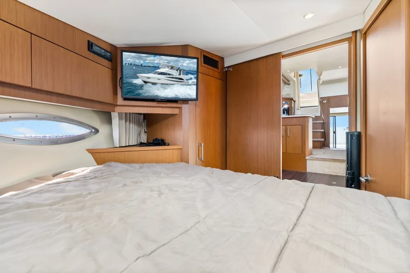 Slide: The Image of Interior of 2012 Carver 41 Cockpit Motor Yacht with bed, TV, and wooden cabinetry. - 40