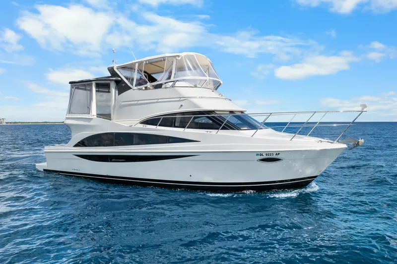 The Image of 2012 Carver 41 Cockpit Motor Yacht cruising on open water under a clear blue sky. - 0