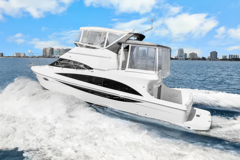 Slide: The Image of 2012 Carver 41 Cockpit Motor Yacht cruising on open water, city skyline in background. - 6