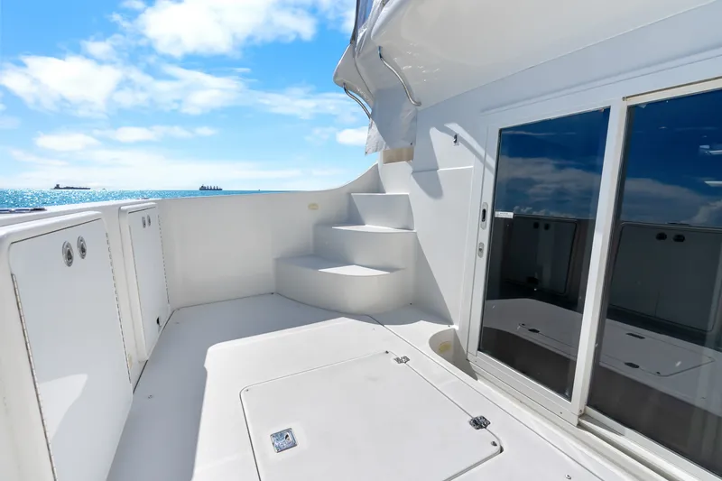 Slide: The Image of 2012 Carver 41 Cockpit Motor Yacht deck with ocean view and clear skies. - 18