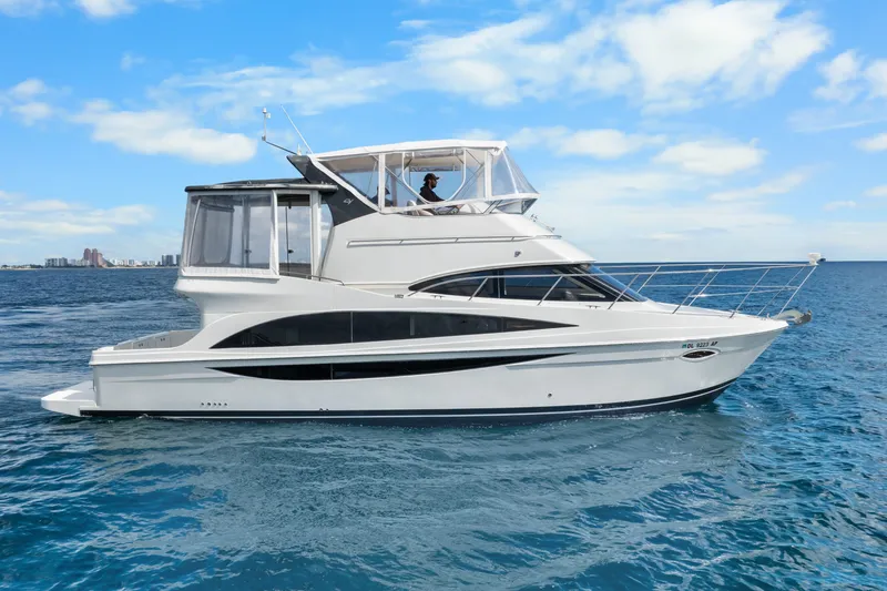 Slide: The Image of 2012 Carver 41 Cockpit Motor Yacht cruising on open water under a clear blue sky. - 2