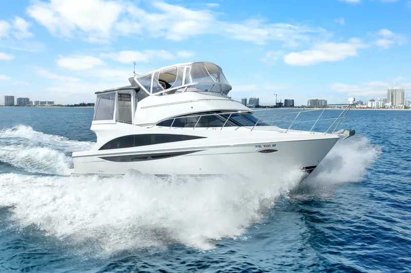 Slide: The Image of 2012 Carver 41 Cockpit Motor Yacht cruising on open water, city skyline in background. - 7