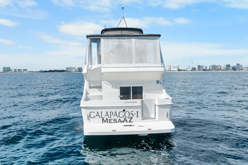 Slide: The Image of 2012 Carver 41 Cockpit Motor Yacht on open water, city skyline in background. - 10
