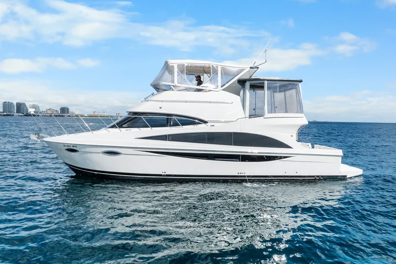 Slide: The Image of 2012 Carver 41 Cockpit Motor Yacht cruising on open water under a clear blue sky. - 3
