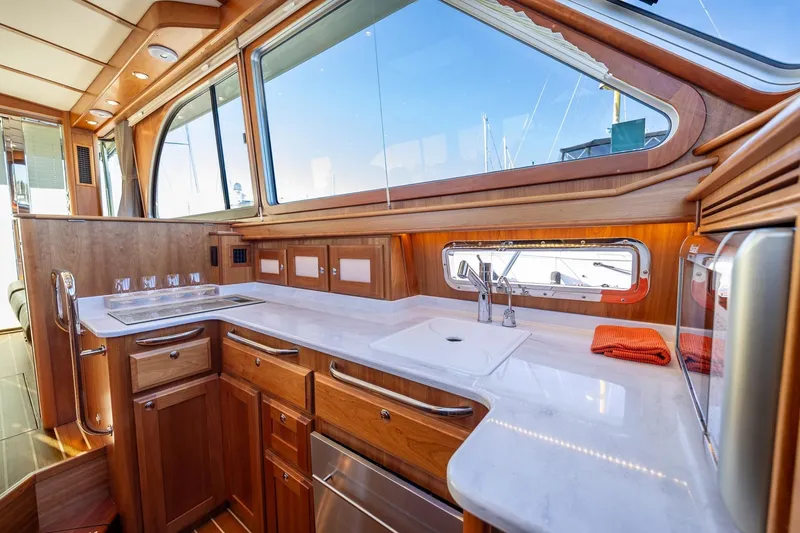 Slide: The Image of Luxurious 2021 Sabre 45 Salon Express yacht interior with elegant wooden cabinetry and modern kitchen amenities. - 22