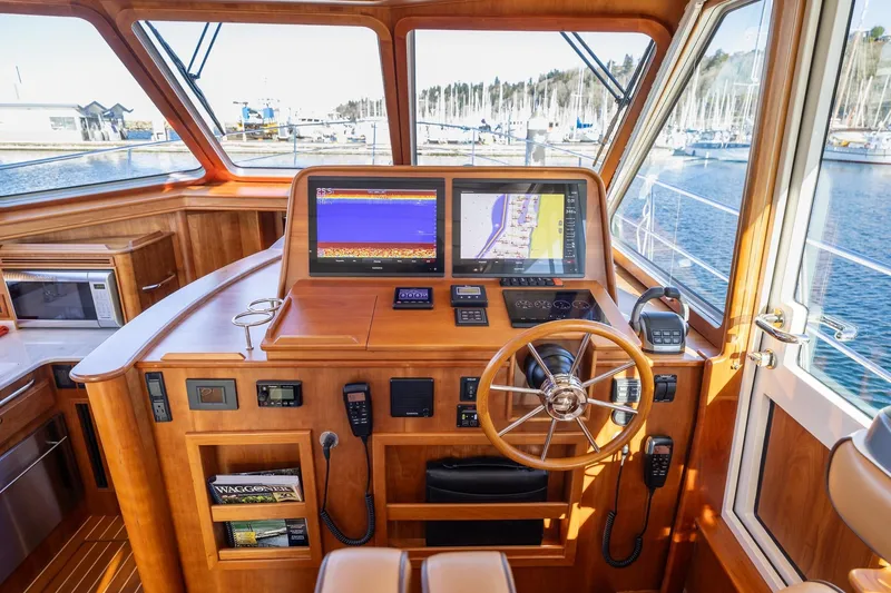 Slide: The Image of 2021 Sabre 45 Salon Express helm with navigation screens and wooden steering wheel. - 17