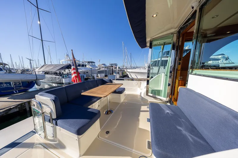 Slide: The Image of 2021 Sabre 45 Salon Express yacht with outdoor seating at marina. - 8