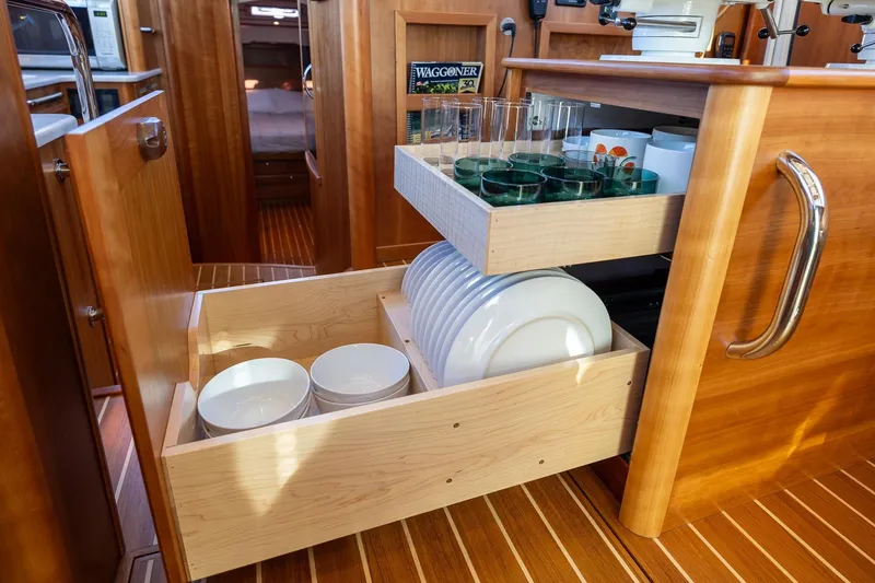 Slide: The Image of 2021 Sabre 45 Salon Express kitchen with wooden cabinetry and organized dish storage. - 26