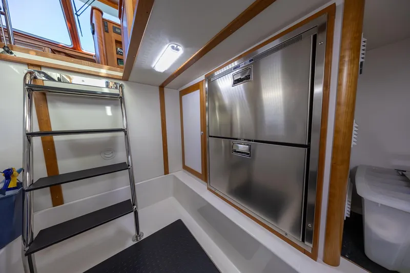 Slide: The Image of Interior of 2021 Sabre 45 Salon Express with stainless steel appliances and ladder. - 37