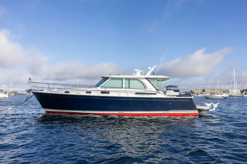 The Image of 2021 Sabre 45 Salon Express yacht on calm water under a clear blue sky. - 0