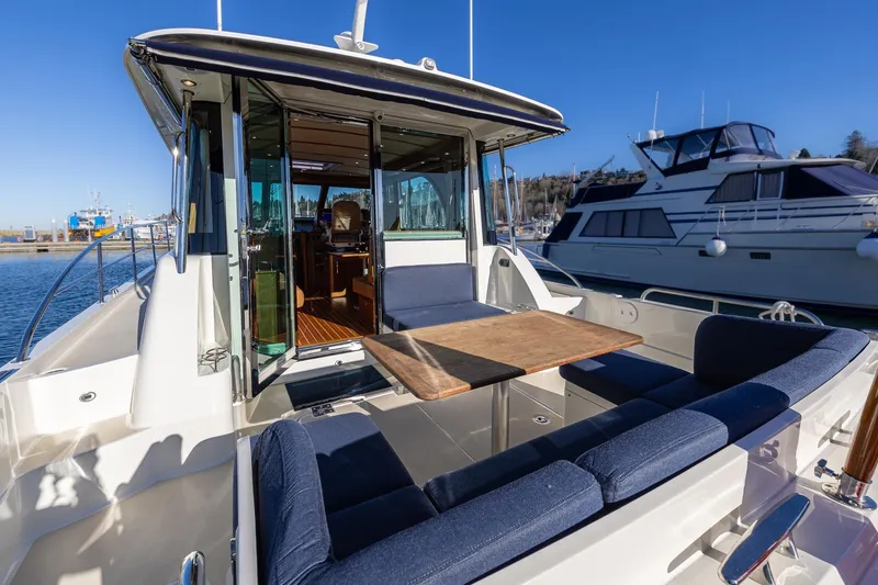 Slide: The Image of 2021 Sabre 45 Salon Express yacht with outdoor seating and table, docked in marina. - 6