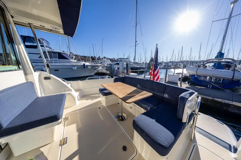 Slide: The Image of 2021 Sabre 45 Salon Express yacht interior with seating, table, and marina view. - 7