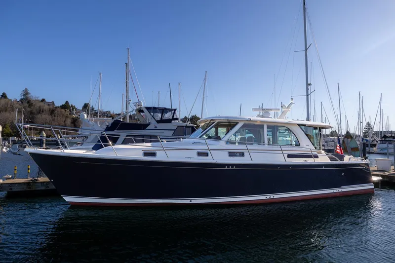Slide: The Image of 2021 Sabre 45 Salon Express yacht docked at marina under clear blue sky. - 2