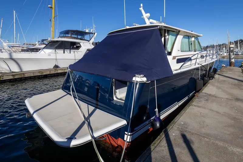 Slide: The Image of 2021 Sabre 45 Salon Express yacht docked at marina under clear blue sky. - 4