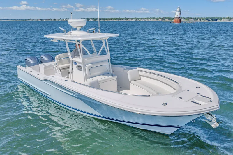 Slide: The Image of 2016 Buddy Davis 28 Center Console boat on open water near a lighthouse. - 0