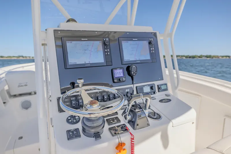 Slide: The Image of 2016 Buddy Davis 28 Center Console boat dashboard with navigation screens and controls. - 6