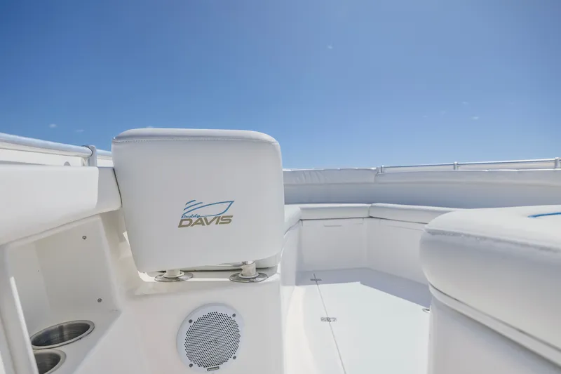 Slide: The Image of 2016 Buddy Davis 28 Center Console boat interior with white seating under clear blue sky. - 13
