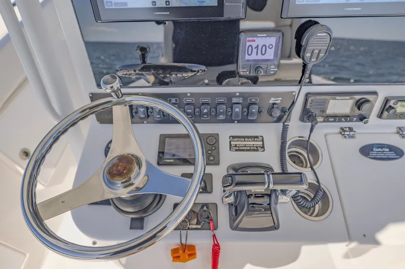 Slide: The Image of 2016 Buddy Davis 28 Center Console helm with steering wheel and navigation controls. - 7