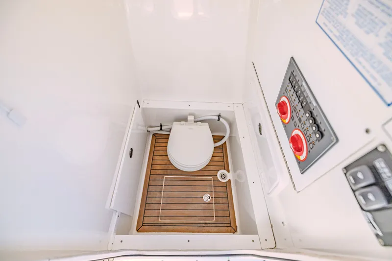 Slide: The Image of Interior of 2016 Buddy Davis 28 Center Console boat with marine toilet and control panel. - 15