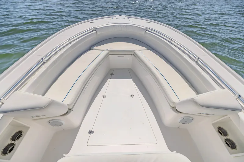 Slide: The Image of 2016 Buddy Davis 28 Center Console boat interior with cushioned seating on calm water. - 14