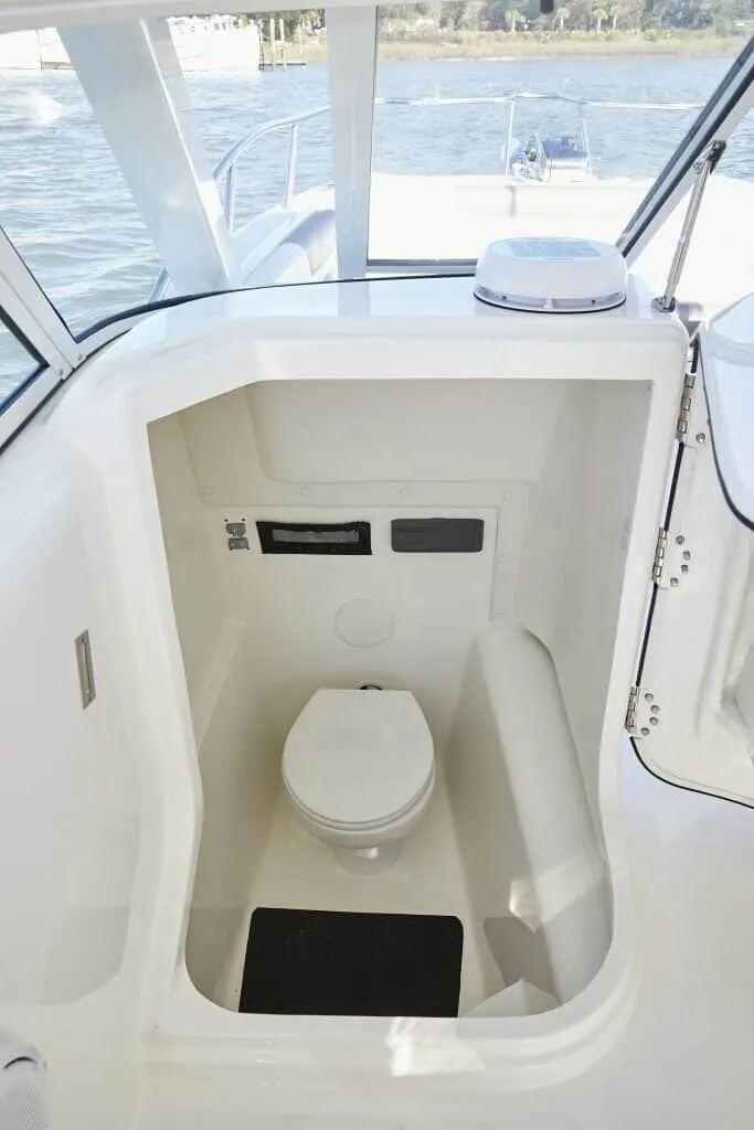 Slide: The Image of The image shows a compact boat toilet with a white interior and a small window. - 15