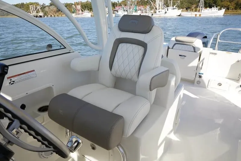Slide: The Image of A luxurious captain's chair on a boat overlooking the water with other boats in the background. - 21