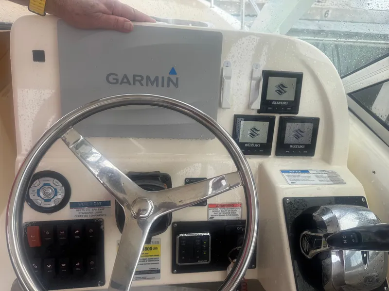 Slide: The Image of The image shows a boat's helm with a Garmin navigation system and Suzuki instruments. - 10