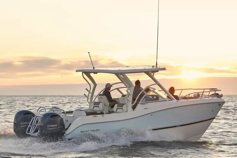 Slide: The Image of A 2013 World Cat 255 DC cruising on the sea at sunset with three people on board. - 1