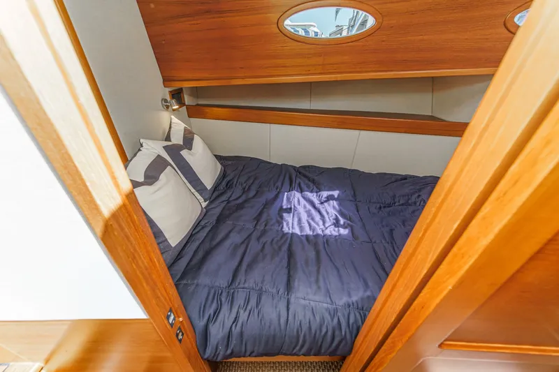 Slide: The Image of 2019 Palm Beach Motor Yachts Express cabin with cozy bed and wooden interior. - 27