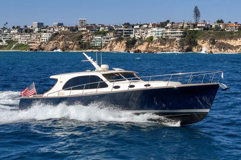 Slide: The Image of 2019 Palm Beach Motor Yachts Express cruising near coastal cliffs and luxury homes. - 31