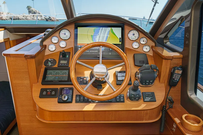 Slide: The Image of 2019 Palm Beach Motor Yachts Express helm with wooden steering wheel and navigation controls. - 21