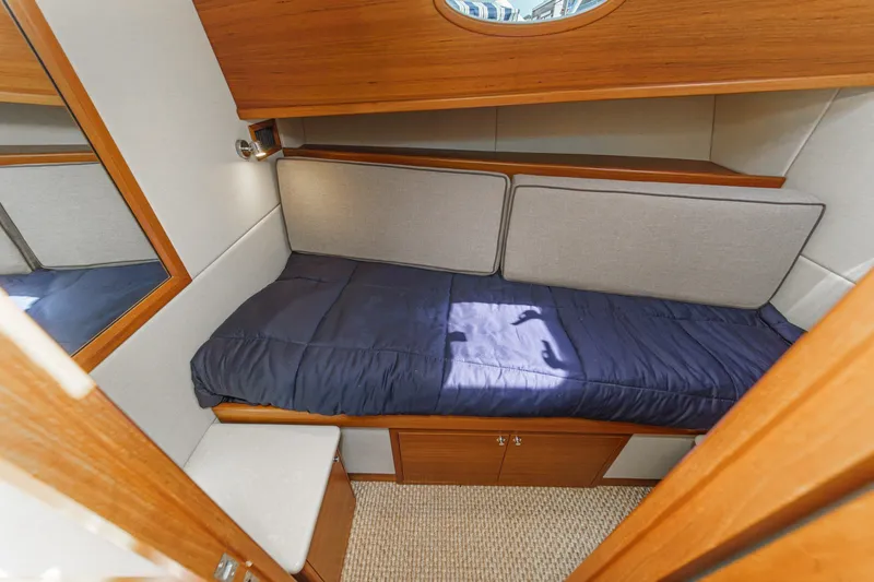 Slide: The Image of 2019 Palm Beach Motor Yachts Express cabin with cozy bed and wooden interior. - 26