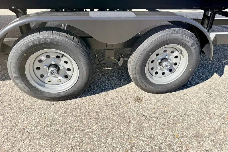 Slide: The Image of Trailer wheels of a 2000 Harris-Kayot Classic 220 O/B on asphalt. - 74