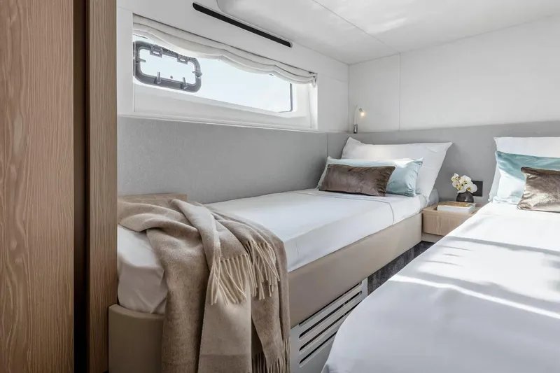 Slide: The Image of Manufacturer Provided Image: Luxurious twin bedroom in 2025 Azimut Fly 53 yacht, featuring elegant decor and natural light. - 13
