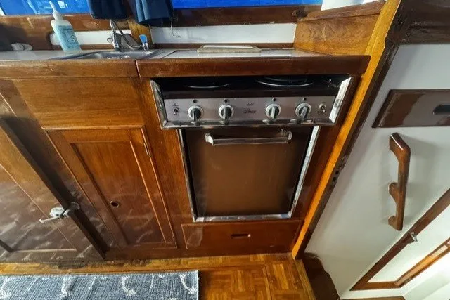 Slide: The Image of 1974 Grand Banks 32 Sedan kitchen with wooden cabinetry and stove. - 11