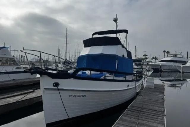 Slide: The Image of 1974 Grand Banks 32 Sedan docked at marina under cloudy sky. - 1