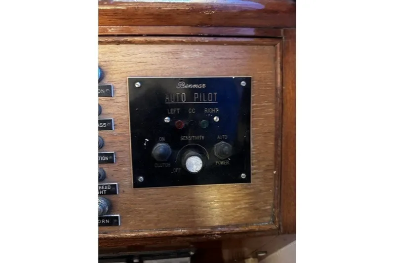 Slide: The Image of 1974 Grand Banks 32 Sedan autopilot control panel with wooden finish and labeled buttons. - 9