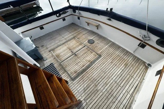 Slide: The Image of 1974 Grand Banks 32 Sedan boat deck with wooden flooring and stairs. - 2