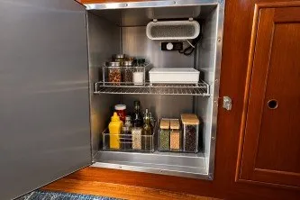 Slide: The Image of Storage cabinet on 1974 Grand Banks 32 Sedan with organized spices and condiments. - 10