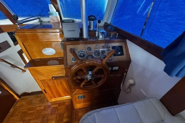 Slide: The Image of 1974 Grand Banks 32 Sedan helm with wooden steering wheel and navigation instruments. - 5