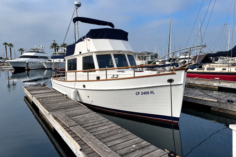 The Image of 1974 Grand Banks 32 Sedan docked at marina, surrounded by other boats. - 0