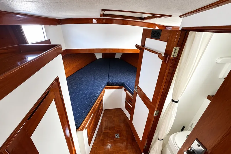 Slide: The Image of 1974 Grand Banks 32 Sedan cabin interior with wooden finish and blue bedding. - 15