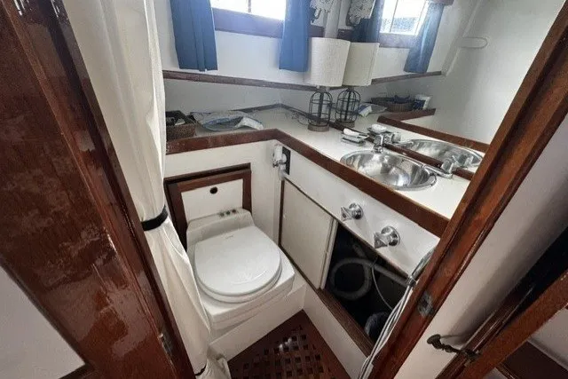 Slide: The Image of 1974 Grand Banks 32 Sedan bathroom with sink, toilet, and wooden accents. - 16