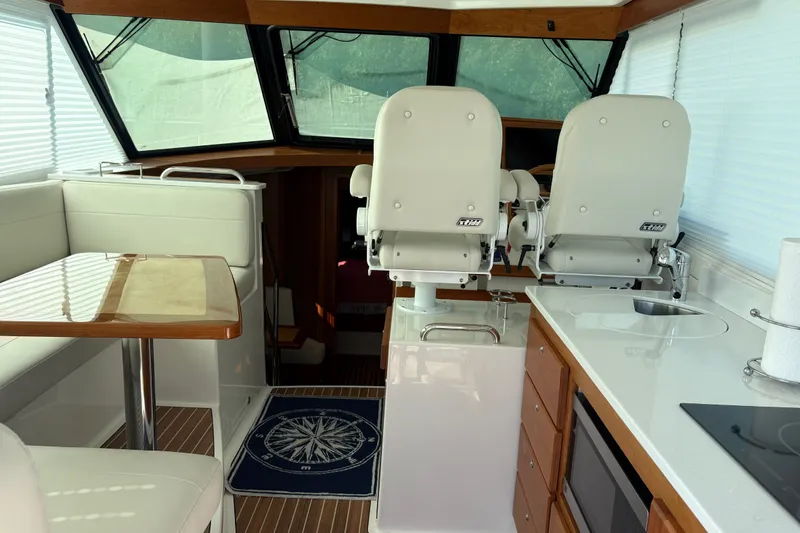 Slide: The Image of Interior of 2025 Back Cove 39O yacht with helm chairs, dining area, and kitchenette. - 22
