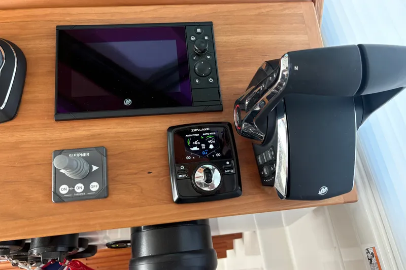 Slide: The Image of 2025 Back Cove 39O helm controls with navigation and throttle systems. - 30