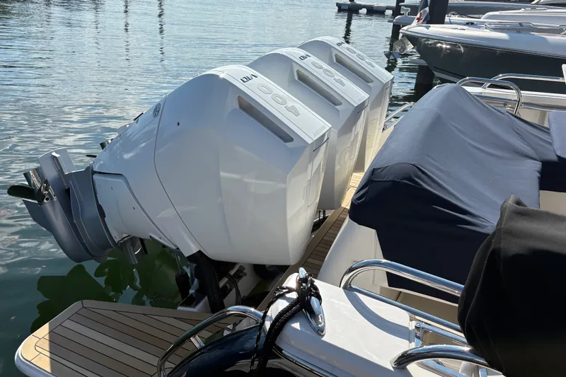 Slide: The Image of 2025 Back Cove 39O boat with triple outboard engines docked on calm water. - 3