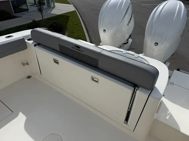 Slide: The Image of The 2024 Cobia 280 Center Console features a cushioned bench seat and two outboard engines. - 9