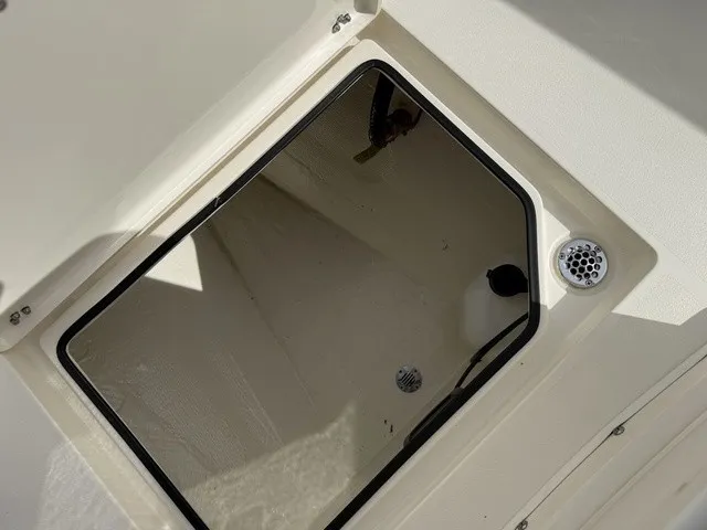 Slide: The Image of An open storage compartment on a 2024 Cobia 280 Center Console boat. - 32