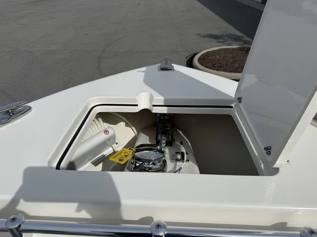 Slide: The Image of The bow of a 2024 Cobia 280 Center Console boat features an open storage compartment with a windlass. - 33